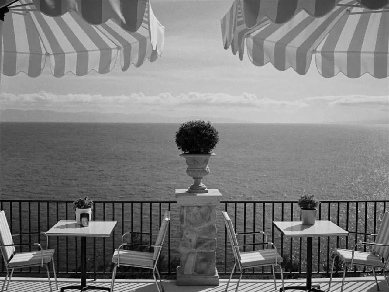 Argent 400 film stock in Chromogen, a true-black mono negative: a black and white seaside terrace under striped umbrellas