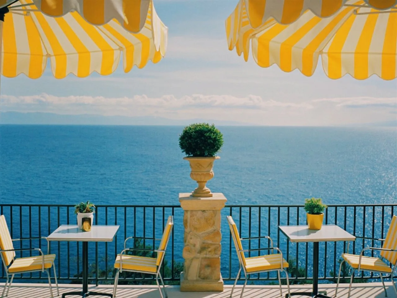Meridian 250 film stock in Chromogen, a daylight cine film: a seaside terrace under yellow striped umbrellas