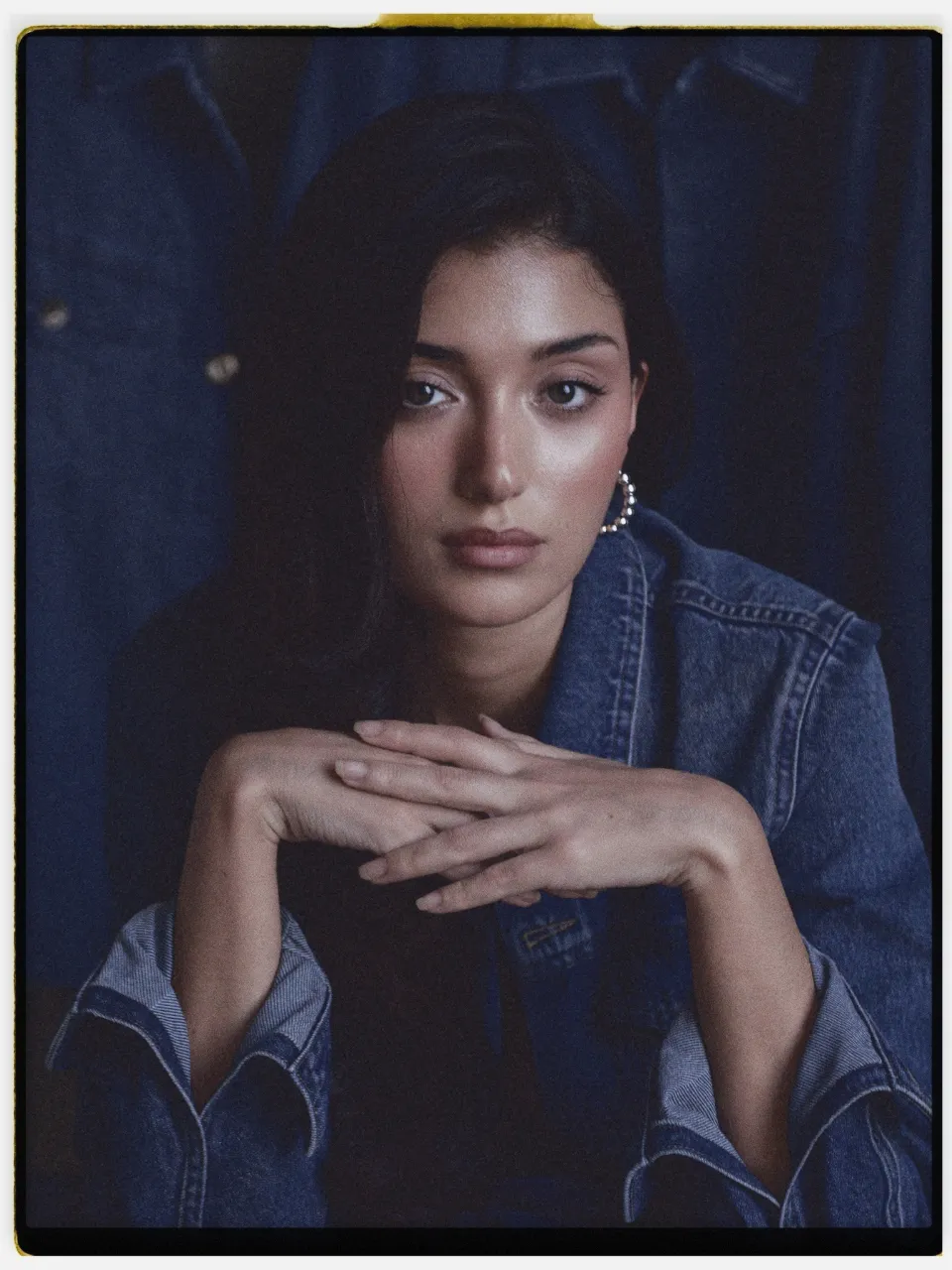 Prisma film stock in Chromogen, a crisp digital slide look: a studio portrait in a denim jacket on an instant-style print