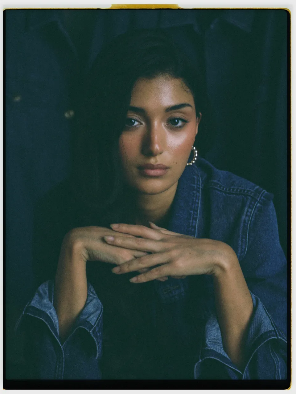 Solia 200 film stock in Chromogen, a golden warm lab scan: a studio portrait in a denim jacket on an instant-style print