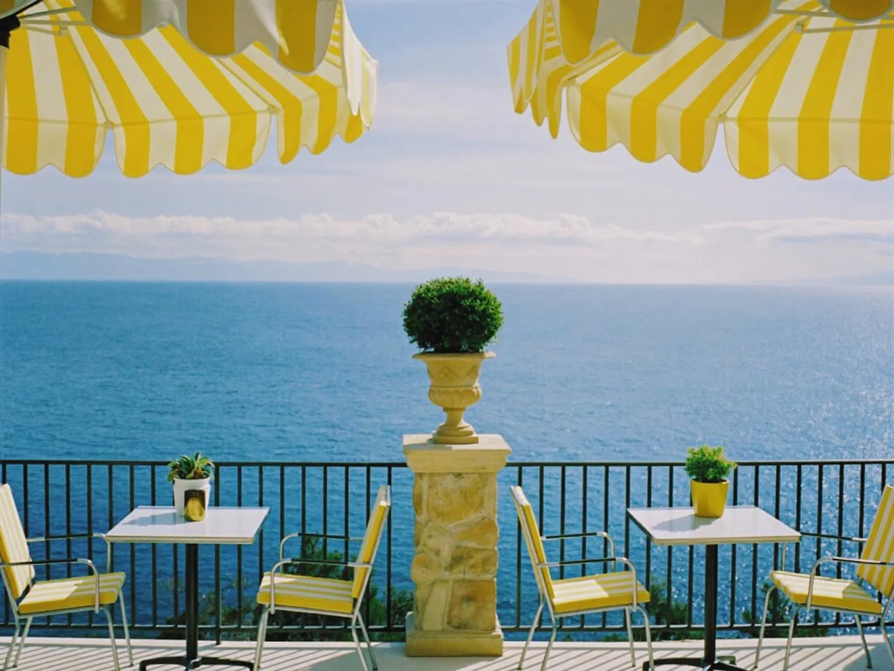 Vesper 400 film stock in Chromogen, a classic consumer negative: a seaside terrace under yellow striped umbrellas