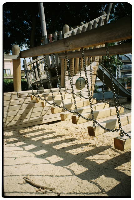 Scout photo on the moodboard: wooden swings casting long shadows on sand
