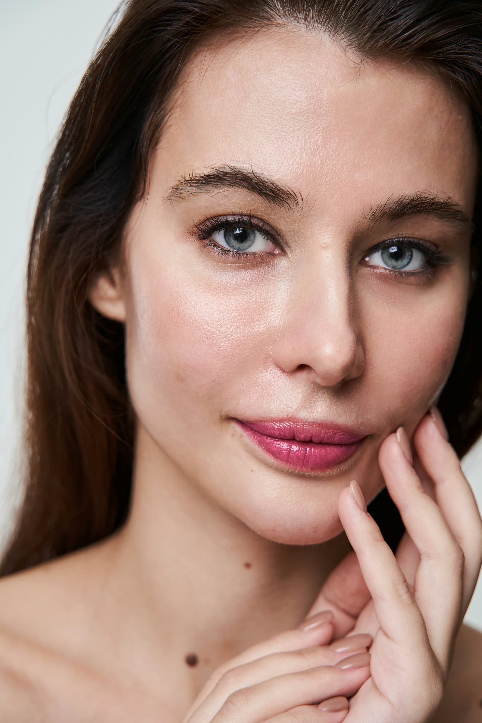 The same portrait with skin, brows, eyes and lips retouched together in Chromogen, real skin texture kept